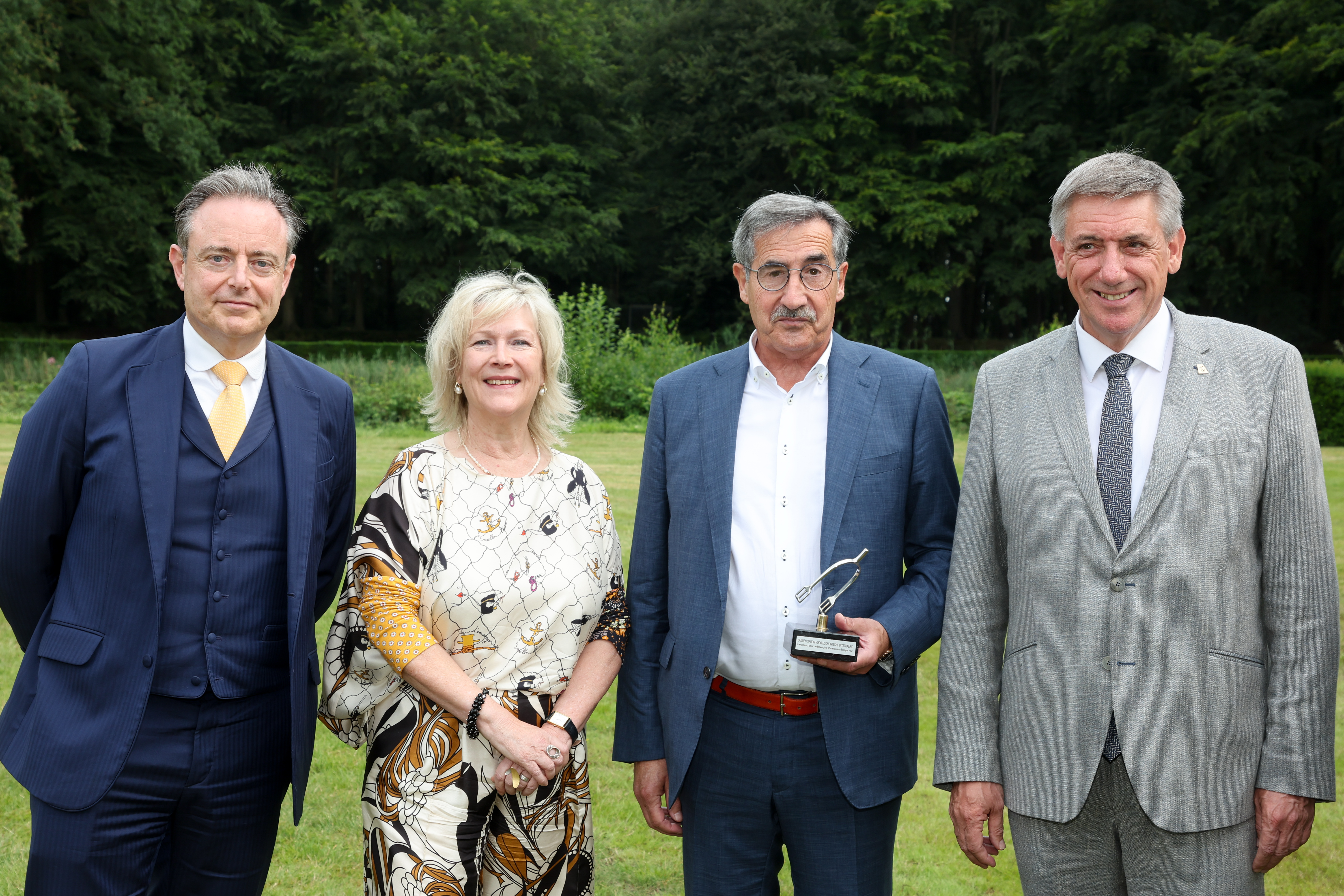 Op de foto zijn we naast André Knaepen huidig premier  Bart De Wever, huidig vice-eersteminister en minister van  Financiën en Pensioenen Jan Jambon en An De Moor.